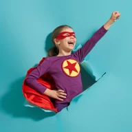 Dziewczynka ubrana w strój fioletowy bohatera z czerwoną peleryną